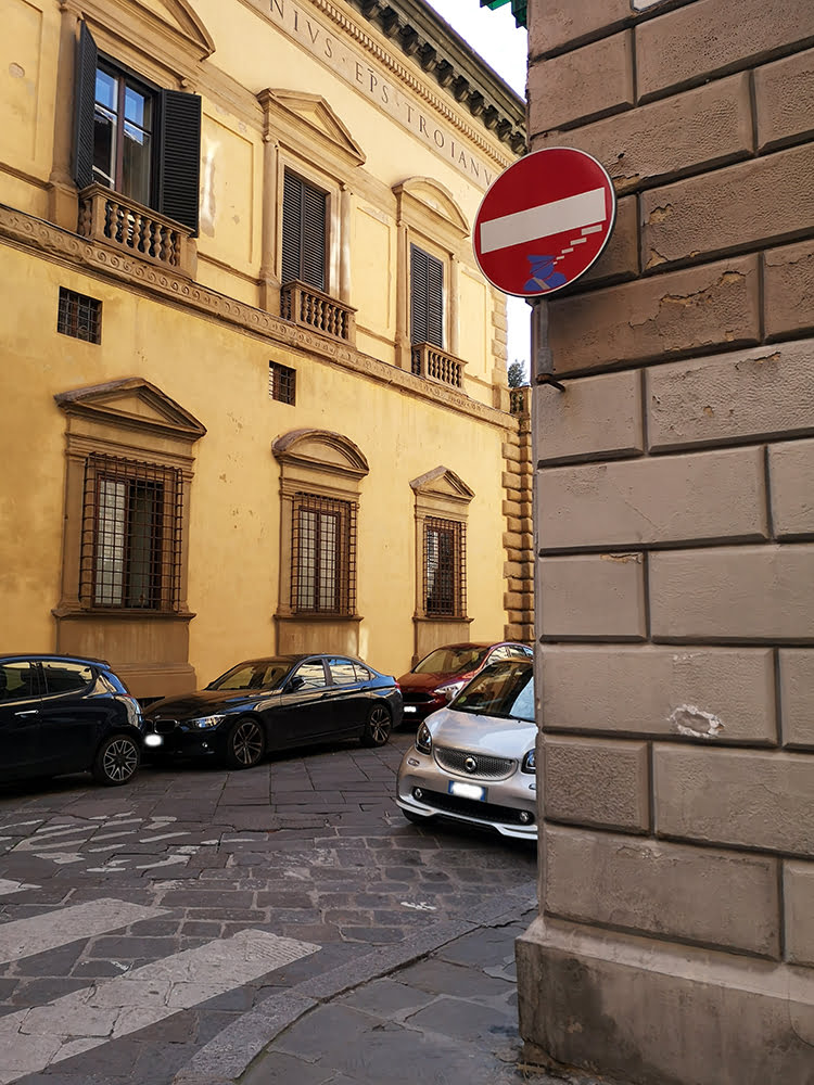 Clet's sign on the background of Raphael's Palazzo Pandolfini