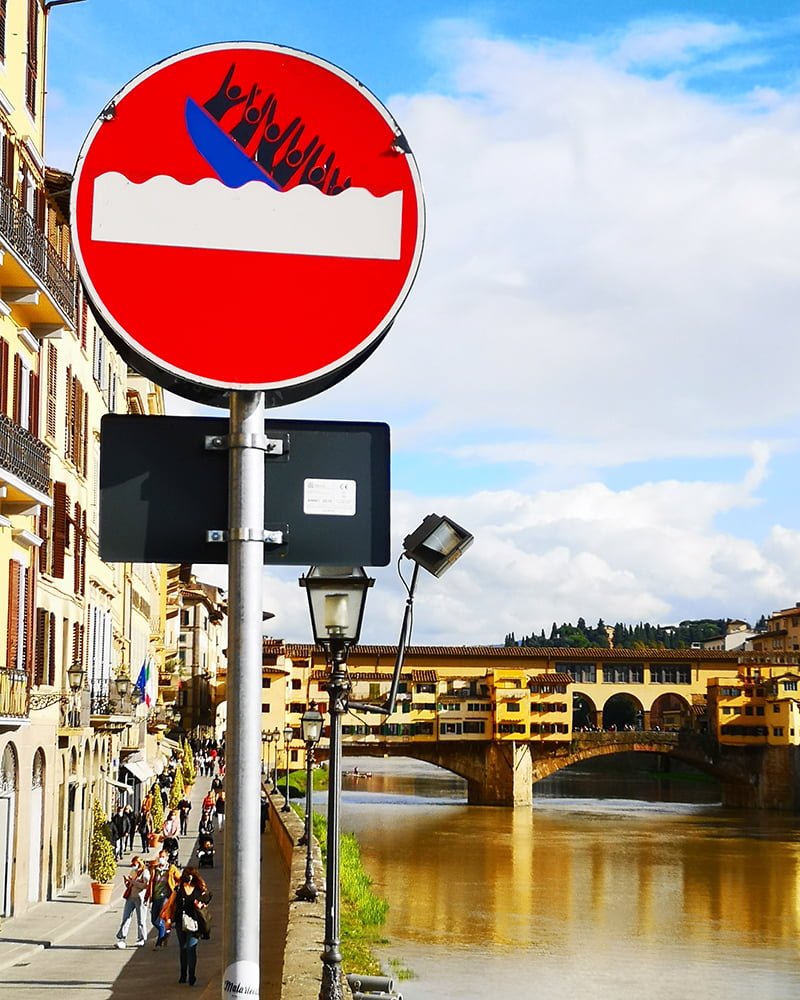 Clet's sign with the Ponte Vecchio in the background